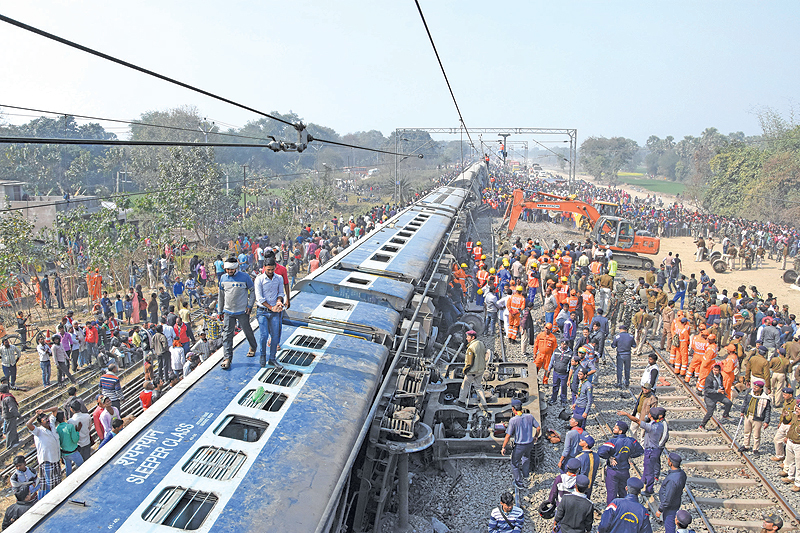 National Disaster Response Force and police personnel along with onlookers stand next to derailed carriages after a train came off the tracks near Hajipur on the outskirts of Patna in India’s eastern Bihar state. — AFP