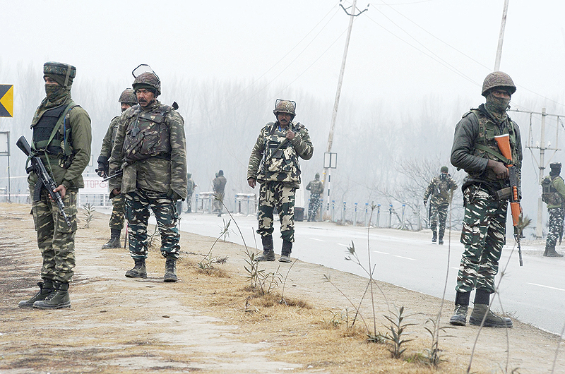 PAMPORE: Indian security forces stand guard along the Jammu-Srinagar highway in Lethpora area in the town of Pampore, some 30 kms South of Srinagar. — AF