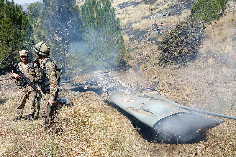 BHIMBAR, Pakistan: Pakistani soldiers stand next to what Pakistan says is the wreckage of an Indian fighter jet shot down in Pakistan-controlled Kashmir in the Somani area in this district near the Line of Control yesterday.