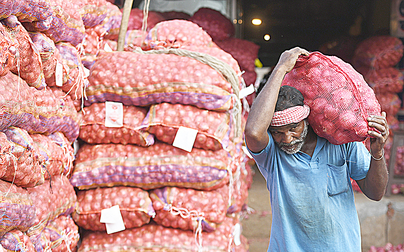 CHENNAI: An Indian laborer carries a sack of onions at a wholesale market in Chennai. India's government unveiled on Friday a raft of budget sweeteners for farmers, the middle class and also cows, as Prime Minister Narendra Modi seeks to shore up support with elections looming. -AFP