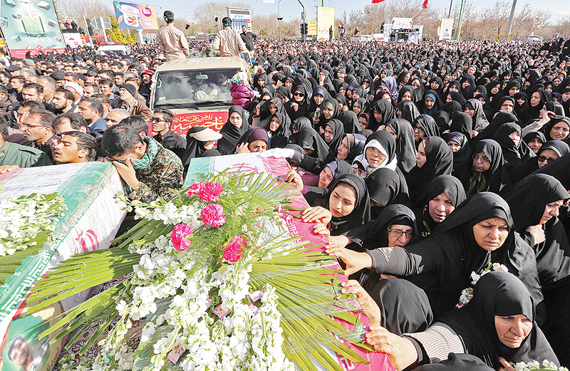 ISFAHAN, Iran: Mourners gather around the coffins of slain Revolutionary Guards during their funeral yesterday. — AFP