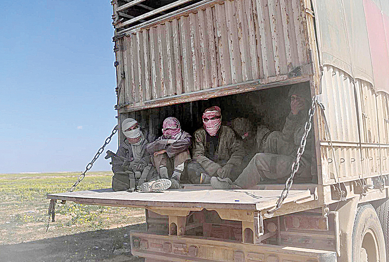 BAGHOUZ: Islamic State group’s fighters and their families sit in the back of a truck as they leave IS’s last holdout of Baghouz in Syria’s northern Deir Ezzor province yesterday. —AFP
