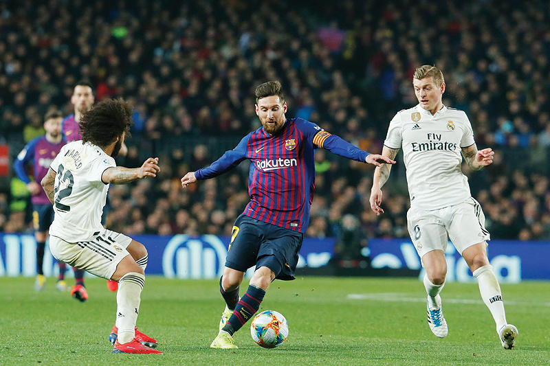 BARCELONA: Barcelona's Argentinian forward Lionel Messi (C) vies for the ball with Real Madrid's Brazilian defender Marcelo (L) and Real Madrid's German midfielder Toni Kroos during the Spanish Copa del Rey (King's Cup) semi-final first leg football match between FC Barcelona and Real Madrid CF at the Camp Nou stadium. - AFP