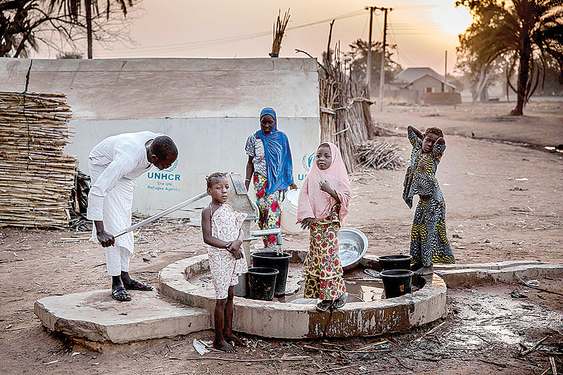JIMETA, Nigeria: Camp dwellers pump water from a well in the early morning at Malkohi refugee camp in Jimeta, Adamawa State. Malkohi is a camp for internal displaced who fled their homes as Boko Haram insurgents advanced across northeastern Nigeria. —AFP