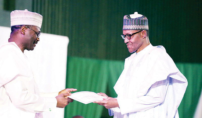 ABUJA: Nigeria’s Independent National Electoral Commission (INEC) chairman Mahmood Yakubu (left) presents to Nigerian President Muhammadu Buhari his certificate of election after he was re-elected yesterday in Abuja. —