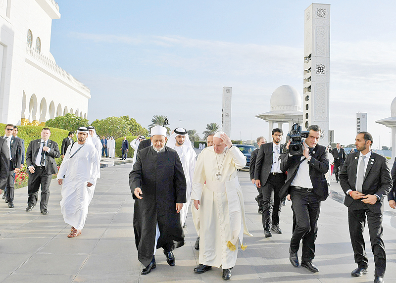 ABU DHABI: This handout picture released by the Vatican press office on February 4, 2019 shows Pope Francis (C-R) walking alongside Egypt's Azhar Grand Imam, Sheikh Ahmed Al-Tayeb (C-L), as they arrive at Sheikh Zayed Grand Mosque. - AFP