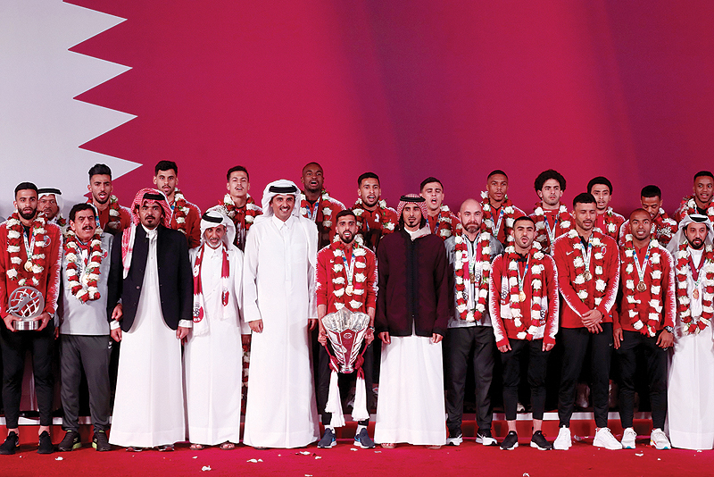 DOHA: Qatar's Amir Sheikh Tamim bin Hamad Al-Thani welcomes the Qatari national football team at Doha airport yesterday. - AFP 