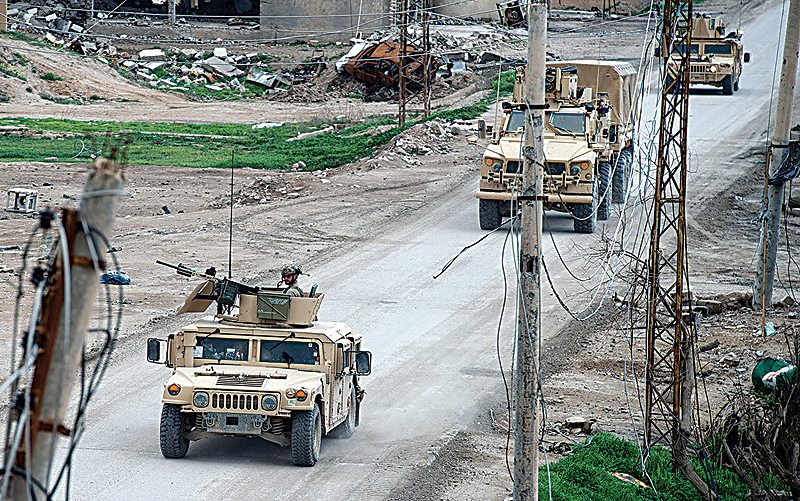 BAGHUZ: Vehicles belonging to the US-led coalition drive down a street in the frontline Syrian village of Baghuz. —AFP