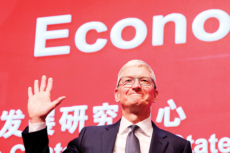 BEIJING: Apple CEO Tim Cook waves as he arrives for the Economic Summit held for the China Development Forum in Beijing. — AFP