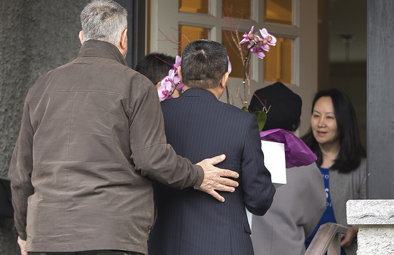 VANCOUVER: In this file photo taken on Dec 12, 2018, Meng Wanzhou (right), Chief Financial Officer of Huawei Technologies, answers the door for individuals carrying flowers after she was released on bail. – AFP  