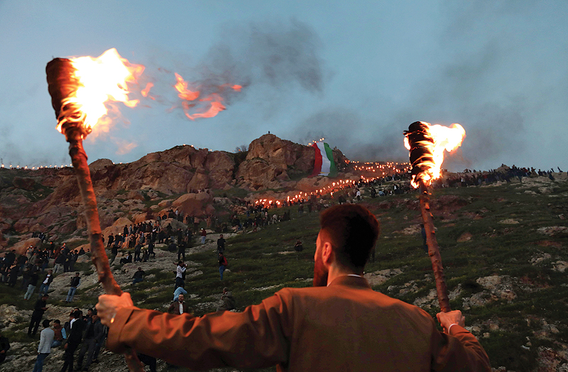 AKRE: An Iraqi Kurd holds lit torches in the town of Akra, 500 kilometers north of the capital Baghdad, during celebrations of Nowruz (Noruz), the Persian New Year. The Persian New Year is an ancient Zoroastrian tradition celebrated by Iranians and Kurds which coincides with the vernal (spring) equinox and is calculated by the solar calendar. - AFP 