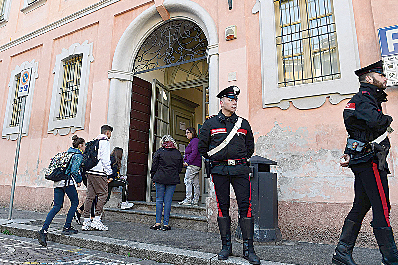 CREMA: Italian Carabinieri policemen stand guard outside the 'Giovanni Vailati' secondary school as pupils arrive for class yesterday in Crema, east of Milan. - AFP 