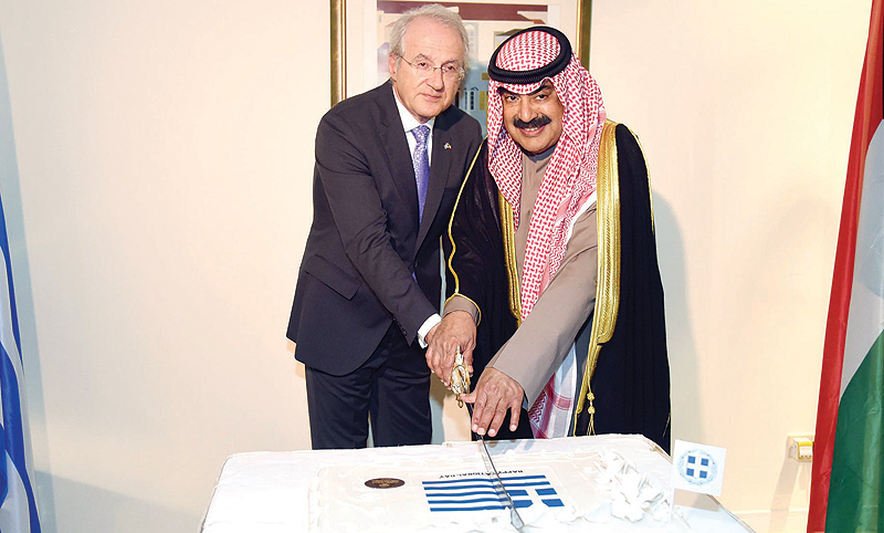 KUWAIT: Deputy Foreign Minister Khaled Al-Jarallah (right) cuts the cake during a reception held by the Greek Embassy to celebrate Greece’s national day. — KUNA