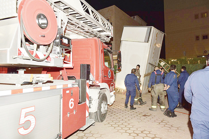 KUWAIT: Firefighters help remove a refrigerated container that fell on two persons in Jahra
