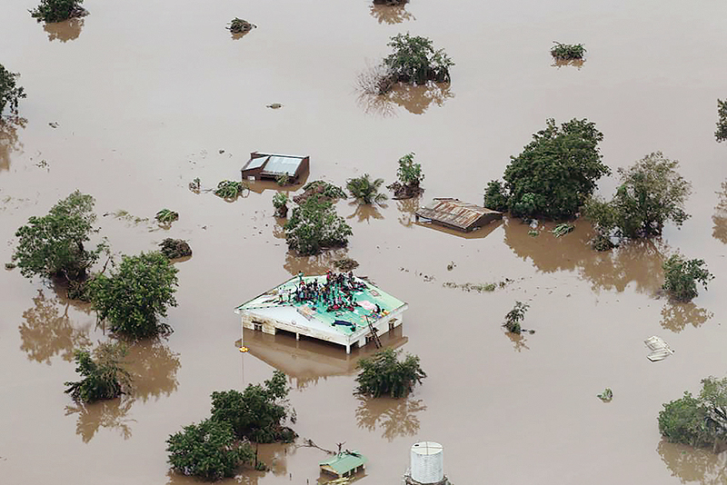 BEIRA, Mozambique: This handout picture taken yesterday shows people on a roof surrounded by flooding in an area affected by Cyclone Idai. - AFP 