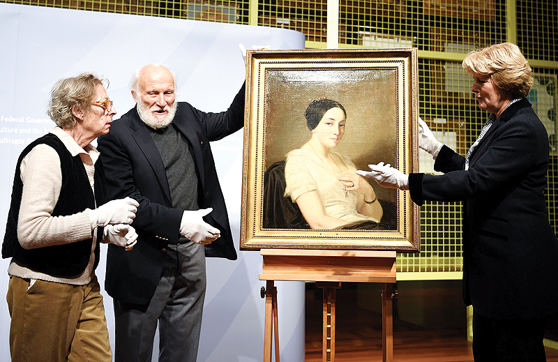 In this file photo the Federal Government’s Commissioner for Culture and the Media Monika Gruetters, right, talks with heirs Maria de las Mercedes Estrada, left, and Wolfgang Kleinertz, center, during the restitution of a painting titled ‘Portrait of a seated woman’ by artist Thomas Couture in Berlin. — AFP