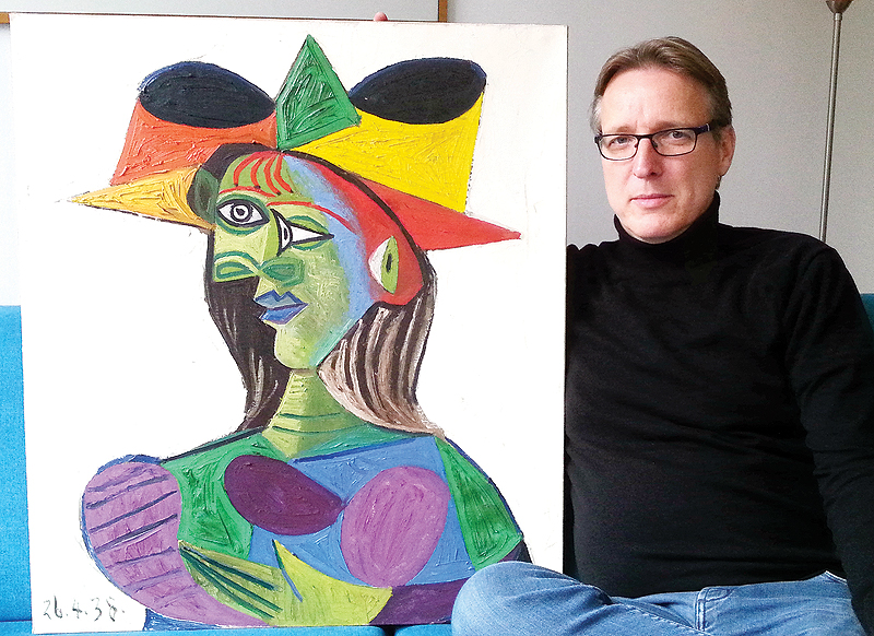 This handout picture released on March 25, 2019 shows Dutch art detective Arthur Brand posing with stolen Picasso painting “Buste de Femme (Dora Maar)” on March 14, 2019 at his Amsterdam home. — AFP