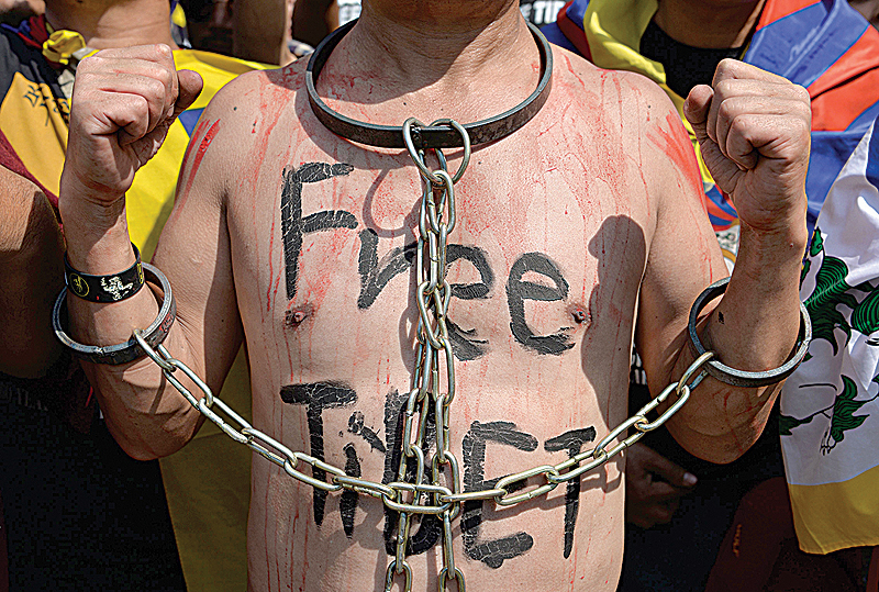 NEW DELHI: An exiled Tibetan activist is handcuffed with chains during a protest marking the 60th anniversary of the 1959 Tibetan uprising against Chinese rule in the Indian capital yesterday. —AFP