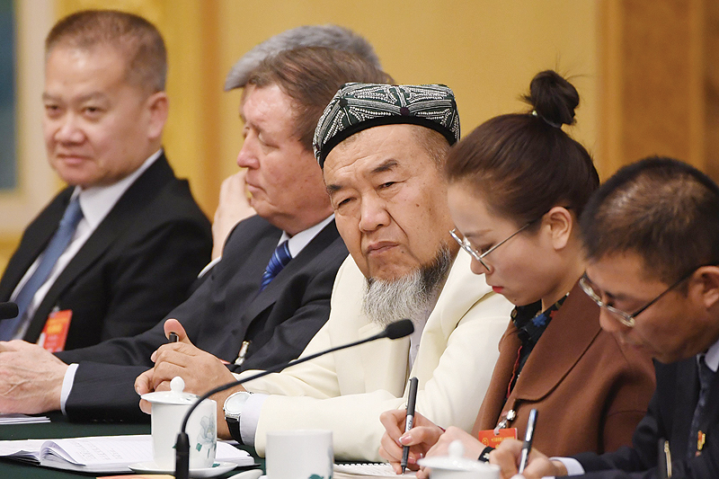 BEIJING: A Uighur delegate (center) attends the Xinjiang delegation meeting at the ongoing National People’s Congress at the Great Hall of the People in Beijing. —AFP