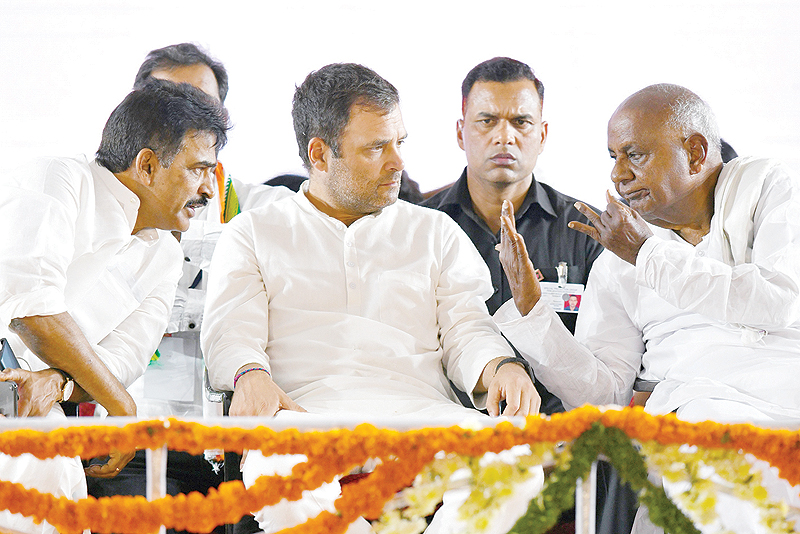 BANGALORE: President of Indian National Congress party Rahul Gandhi (center) and Former Indian Prime Minister and Janata Dal (Secular) Supremo HD Deve Gowda (right) speak while AICC General Secretary KC Venugopal (left) listens during an election campaign rally at Krishnaraja Nagar. —AFP