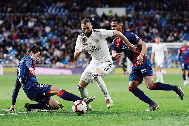 MADRID: Real Madrid's French forward Karim Benzema (C) challenges SD Huesca's Venezuelan midfielder Yangel Herrera (R) and SD Huesca's Argentinian defender Martin Mantovani (L) during the Spanish League football match between Real Madrid CF and SD Huesca at the Santiago Bernabeu stadium in Madrid. - AFP