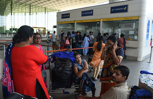 Indian passengers wait by the Jet Airways ticketing counter at Chattrapati Shivaji International Airport in Mumbai on April 18, 2019, after the airline grounded its fleet. - Jet Airways shares plunged more than 32 percent on April 18, hours after the Indian carrier's final flight landed following a decision to ground its entire fleet. (Photo by PUNIT PARANJPE / AFP)