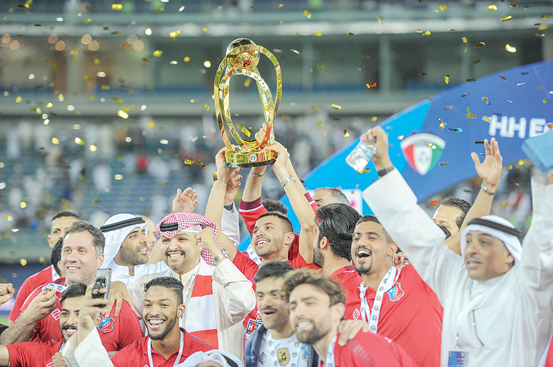 KUWAIT: The victorious Kuwait Sports Club holding HH the Amir trophy after beating Al-Qadsiya in the finals yesterday. — KUNA