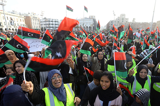 Libyan women wave national flags and chant slogans during a demonstration against strongman Khalifa Haftar in the capital Tripoli's Martyrs Square on April 19, 2019. (Photo by Mahmud TURKIA / AFP)