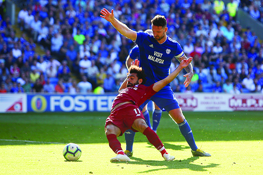 CARDIFF: Liverpool's Egyptian midfielder Mohamed Salah (L) is fouled by Cardiff City's English defender Sean Morrison (R) to earn a penalty leading their second goal during the English Premier League football match between between Cardiff City and Liverpool at Cardiff City Stadium yesterday. - AFP