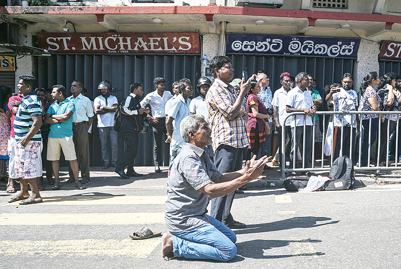 COLOMBO: People pray outside the St Anthony's Shrine in Colombo a day after the building was hit as part of a series of bomb blasts targeting churches and luxury hotels in Sri Lanka. - AFP  
