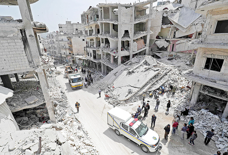 JISR ASH SHUGHUR, Syria: People watch as members of the Syrian Civil Defense, also known as the ‘White Helmets’, search the rubble of a collapsed building following an explosion in the town of Jisr al-Shughur, in the west of the mostly rebel-held Syrian province of Idlib. — AFP