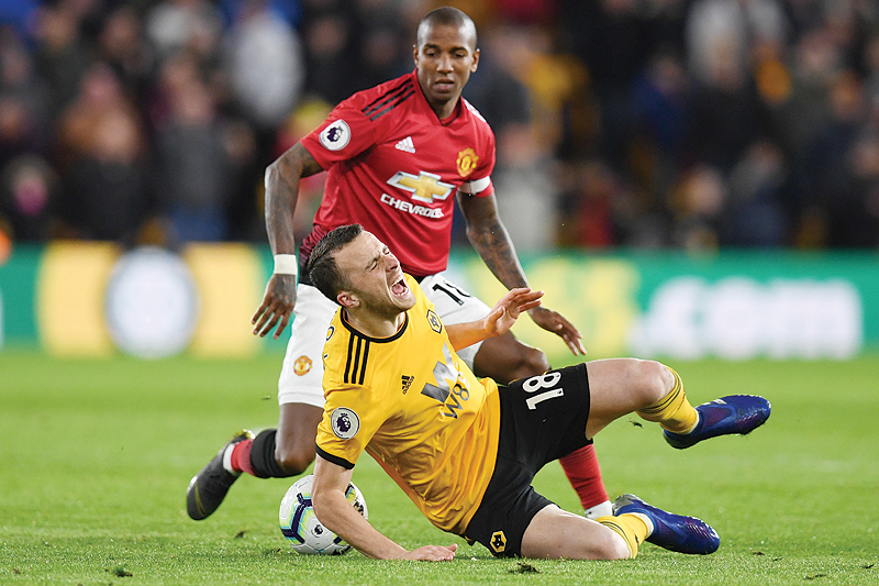 WOLVERHAMPTON: Wolverhampton Wanderers’ Portuguese midfielder Diogo Jota (front) is brought down by Manchester United’s English defender Ashley Young (back) to earn his first yellow card during the English Premier League football match between Wolverhampton Wanderers and Manchester United at the Molineux stadium in Wolverhampton. — AFP