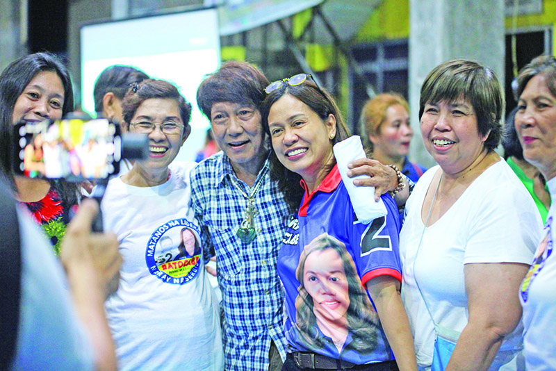 This photo taken on April 30, 2019 shows Gertrudes Batocabe (C), wife of the late congressman Rodel Batocabe, posing for photos with supporters during a campaign rally in the town of Daraga, Albay province, south of Manila. - Batocabe never wanted to enter the Philippines' cutthroat politics, but after her husband was shot dead, allegedly by a rival in midterm elections taking place on May 13, she felt bound to take his place. (Photo by STR / AFP) / TO GO WITH Philippines-election-widows,FOCUS by Cecil Morella