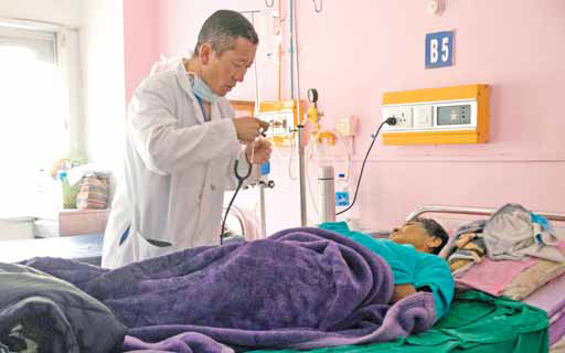 THIMPHU, Bhutan: In this photo Bhutan’s Prime Minister Lotay Tshering treats a patient at the National Referral Hospital in the Bhutanese capital Thimphu. — AFP