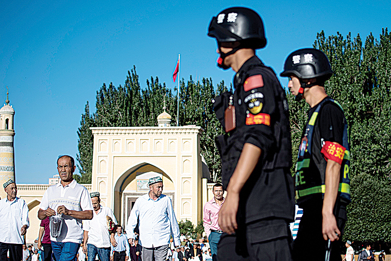 KASHGAR, China: This file photo taken on June 26, 2017 shows police patrolling as Muslims leave the Id Kah Mosque after the morning prayer on Eid Al-Fitr in the old town of Kashgar in China’s Xinjiang Uighur Autonomous Region. —AFP
