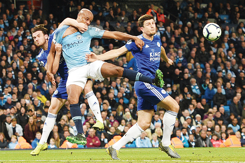 MANCHESTER: Leicester City’s English defender Ben Chilwell (L) and Leicester City’s English defender Harry Maguire (R) battle with Manchester City’s Belgian defender Vincent Kompany (C) during the English Premier League football match between Manchester City and Leicester City at the Etihad Stadium in Manchester, north west England. —AFP