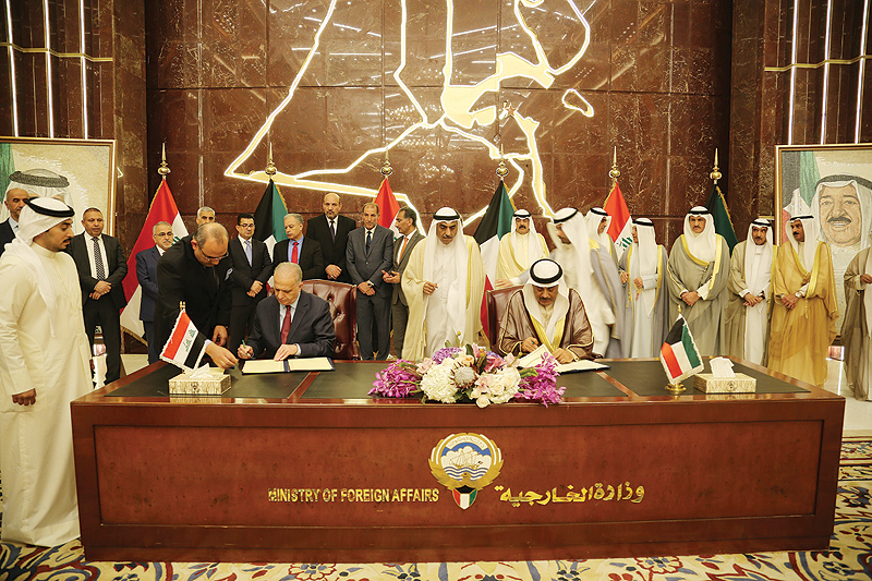 KUWAIT: Deputy Prime Minister and Minister of Foreign Affairs Sheikh Sabah Al-Khaled Al- Hamad Al-Sabah and Iraqi Foreign Minister Dr Mohammad Ali Al-Hakim sign an agreement between the two countries. — KUNA