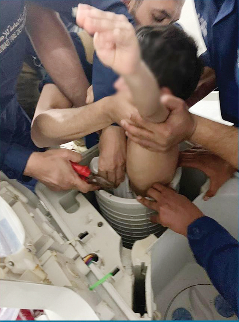 KUWAIT: Firemen free a child who became trapped in a washing machine inside a Firdous house