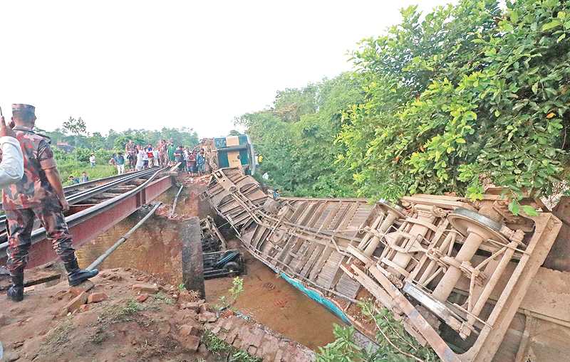 KULAURA: Bangladeshi onlookers gather around a derailed train after a bridge collapse in Kulaura. — AFP