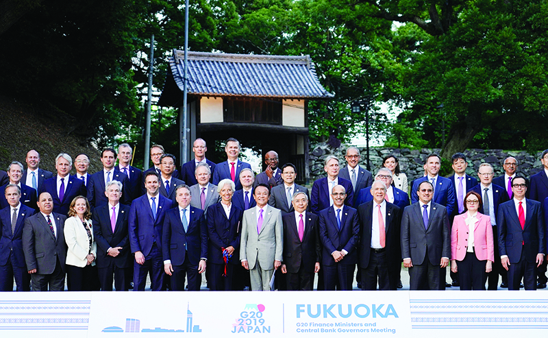 Japan's Finance Minister Taro Aso (C) poses next to IMF managing director Christine Lagarde (centre L) and Bank of Japan governor Haruhiko Kuroda (centre R) during a family photo of the G20 finance ministers and central bank governors meeting in Fukuoka on June 8, 2019. (Photo by FRANCK ROBICHON / POOL / AFP)