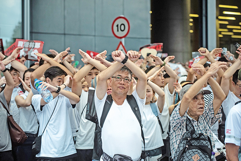 HONG KONG: Protesters gesture as they chant ‘no extradition’ as they rally against a controversial extradition law proposal in Hong Kong yesterday. — AFP