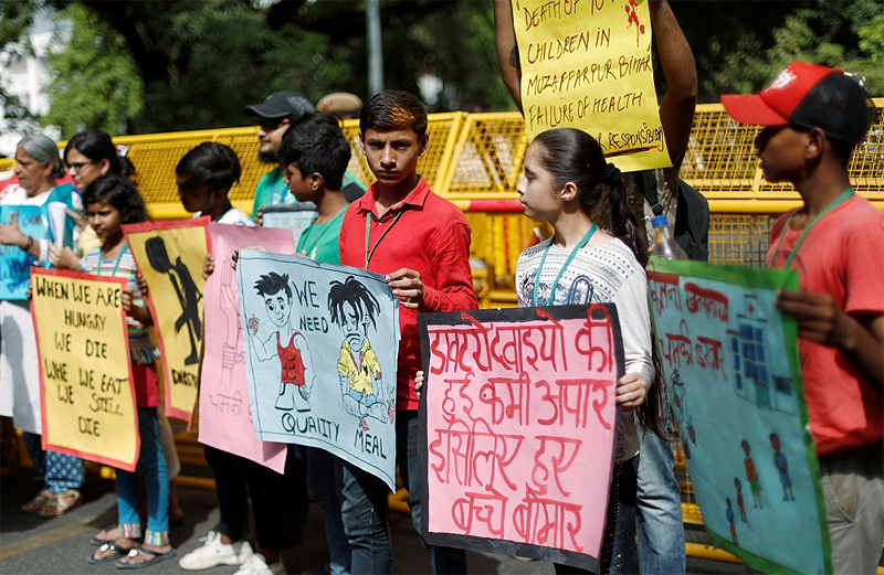 Children hold placards during a protest against the deaths of children who have died this month from encephalitis, commonly known as brain fever, in the eastern Indian state of Bihar, in New Delhi, on Monday. — Reuters