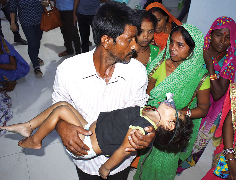 MUZAFFARPUR: In this file photo the father, center, of four-year-old Khushbu Kumari carries his son, who is suffering from Acute Encephalitis Syndrome (AES), at Kejriwal hospital along with relatives before going to another hospital in Muzaffarpur in the Indian state of Bihar. — AFP