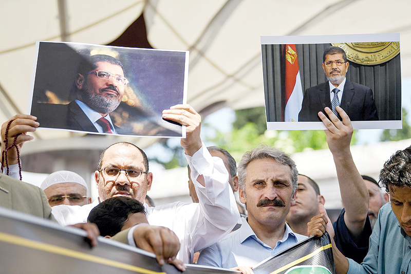 ISTANBUL: People hold picture of Egyptian President Mohamed Morsi during a symbolic funeral ceremony yesterday at Fatih mosque in Istanbul. Thousands joined in prayer in Istanbul yesterday for former Egyptian president Mohamed Morsi who died the previous day after collapsing during a trial hearing in a Cairo court. — AFP