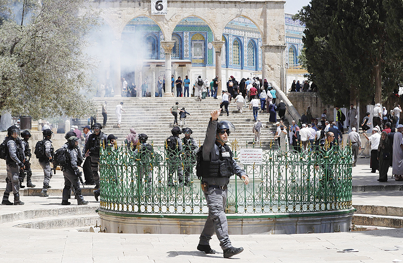 JERUSALEM: A member of the Israeli security forces gestures at Al-Aqsa Mosque compound in the Old City of Jerusalem yesterday, as clashes broke out while Israelis marked Jerusalem Day, which commemorates the country's capture of the city's mainly Palestinian eastern sector in the 1967 Six-Day War. - AFP 