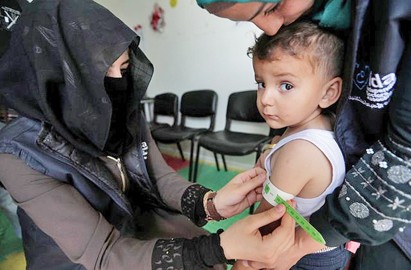AZAZ, Syria: A pediatrician measures a displaced Syrian refugee child at a mobile clinic, in north Azaz, Syria. — Reuters