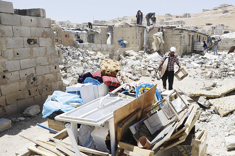 ARSAL, Lebanon: A Syrian man gathers his belongings as workers demolish cement block shelters at a refugee camp in this northeastern Lebanese town in the Bekaa valley on June 10, 2019. – AFP 