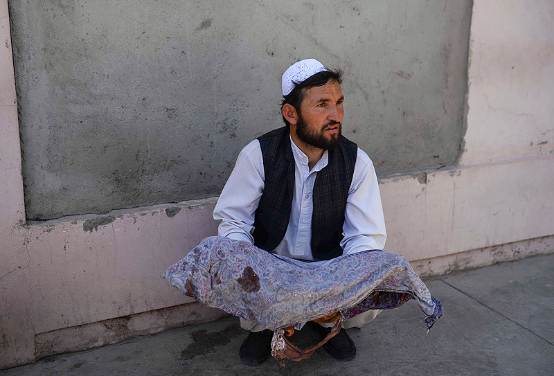  HERAT, Afghanistan: An Afghan man holds the dead body of a child killed when a bus hit a roadside bomb on the Kandahar-Herat highway, at a hospital yesterday. - AFP  