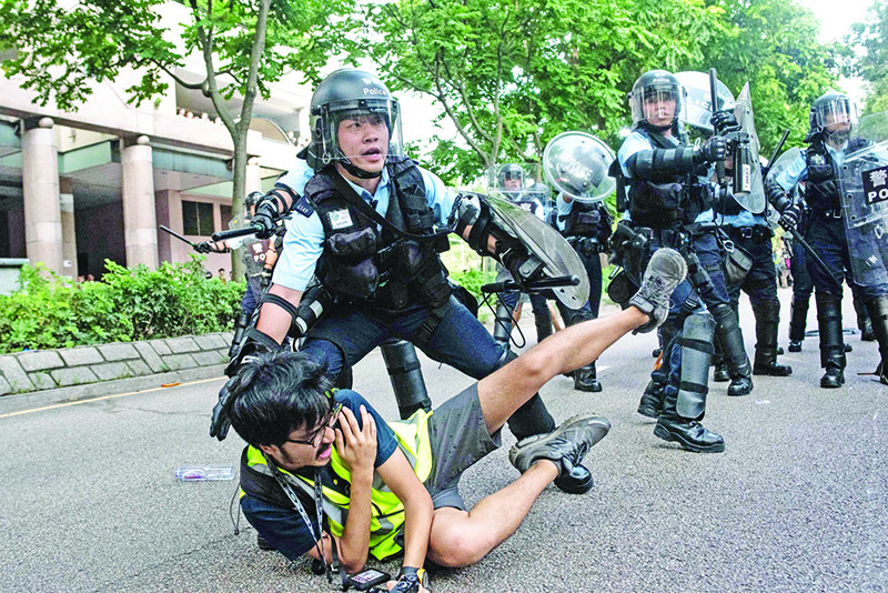 TOPSHOT - A photojournalist falls down during clashes between protesters and police at an anti parallel trading march in Sheung Shui district in Hong Kong on July 13, 2019. (Photo by Philip FONG / AFP)