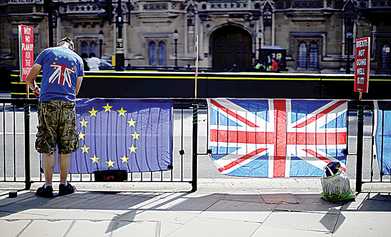 LONDON: An anti-Brexit activist secures an EU flag to a railing opposite the Houses of Parliament in Westminster, central London. —AFP
